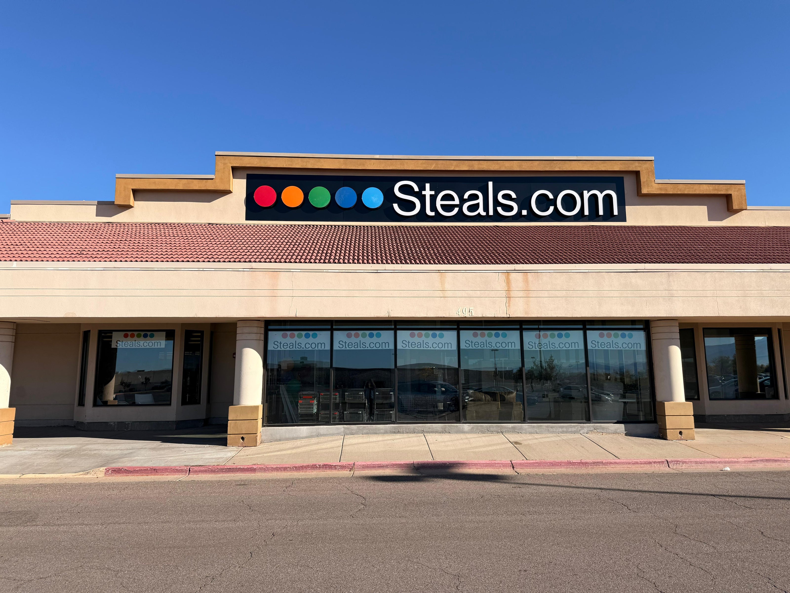 Storefront with 'Steals.com' sign on a clear day