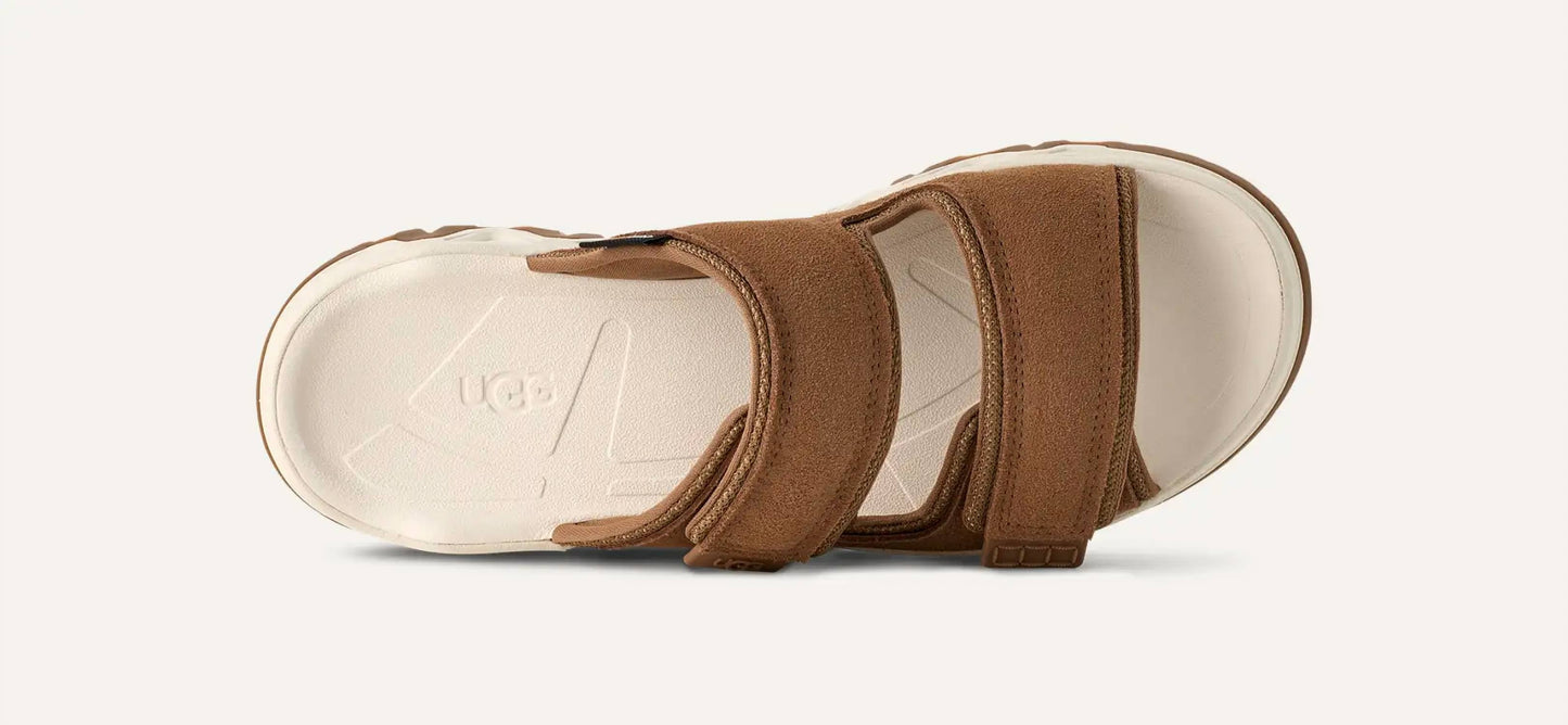 Ugg - महिलाओं के लिए कैपिटल स्ट्रैप स्लाइड सैंडल